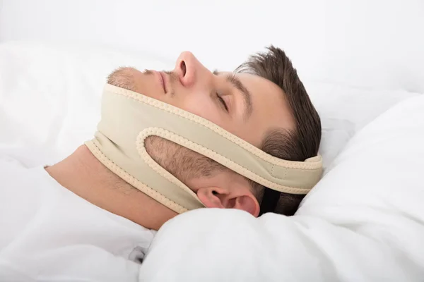 Homem dormindo com cinta de queixo — Fotografia de Stock