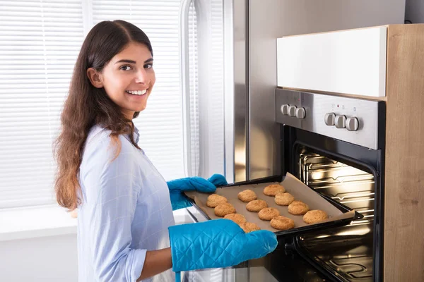 Mujer sacando bandeja — Foto de Stock