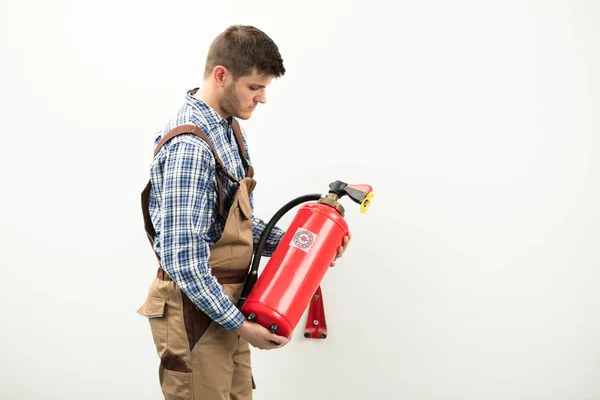 Técnico carregando extintor de incêndio vermelho — Fotografia de Stock