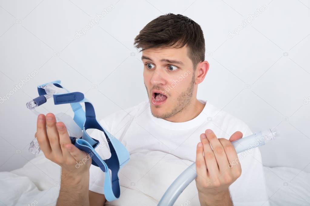 Young Man Holding CPAP Machine