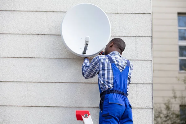 Muž montáž Tv satelit — Stock fotografie