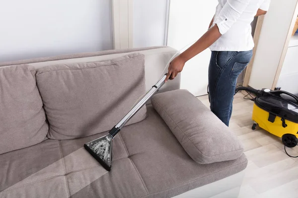 家庭主妇清洁沙发 — 图库照片