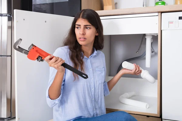 Mujer sosteniendo la tubería del fregadero — Foto de Stock