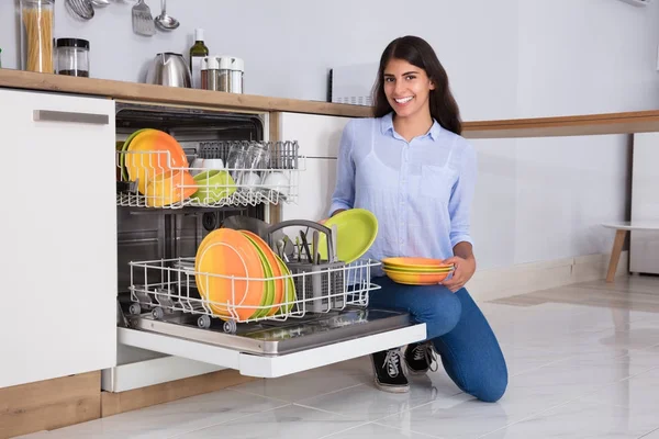 Woman Arranging Plates In Dishwasher — Stock Photo, Image