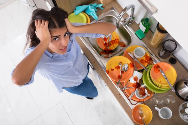 Женщина, стоящая рядом с грязной посудой — стоковое фото