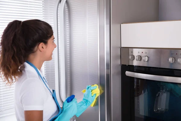 Frau putzt Kühlschrank — Stockfoto