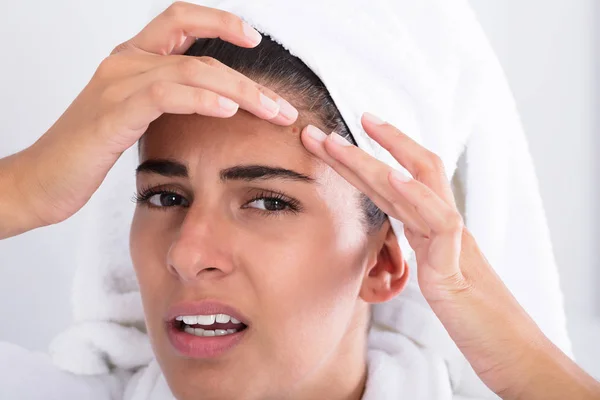 Vrouw kijken naar puistje — Stockfoto