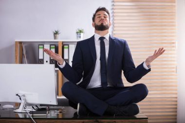 İş adamı ofiste yoga yapıyor.
