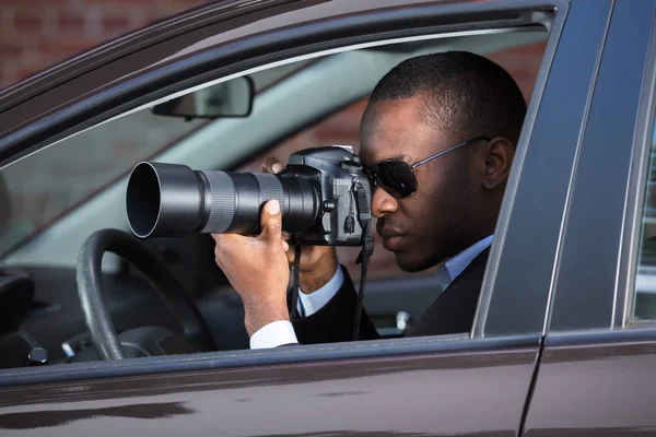 Detektiv som sitter inne i bilen fotograferar — Stockfoto