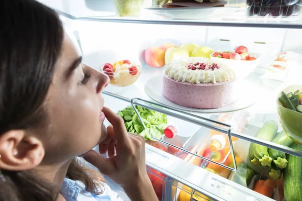 Junge Frau schaut sich Essen an — Stockfoto