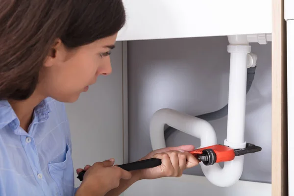 Woman Tightening Sink Pipe — Stock Photo, Image