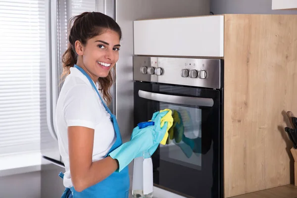 Vrouw schoonmaak oven — Stockfoto