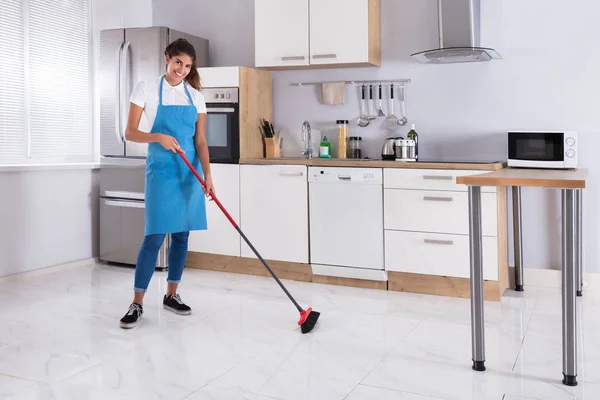 Empregada doméstica limpeza chão com vassoura — Fotografia de Stock