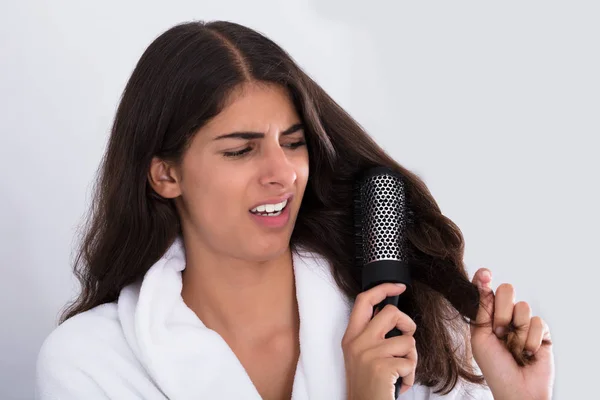 Kadın kıvırcık saçları fırçalama — Stok fotoğraf