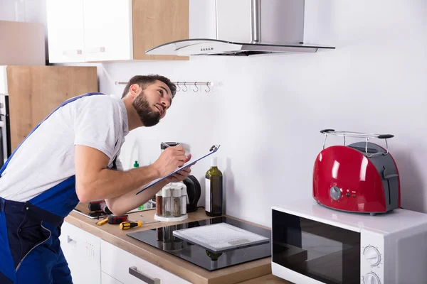 Techniker schreibt auf Klemmbrett — Stockfoto