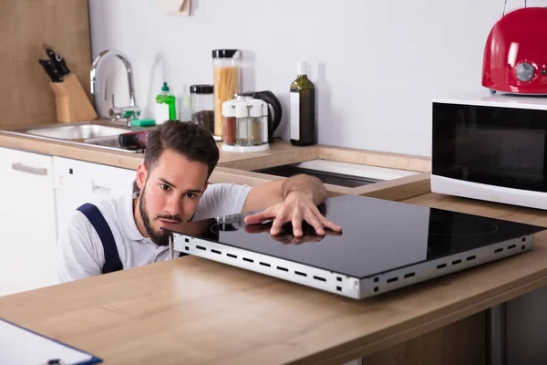 Técnico examinando estufa de inducción — Foto de Stock