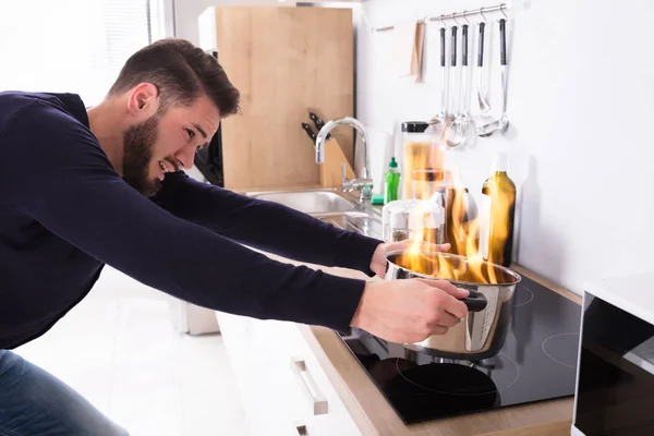 Homem segurando Utensil no fogo — Fotografia de Stock