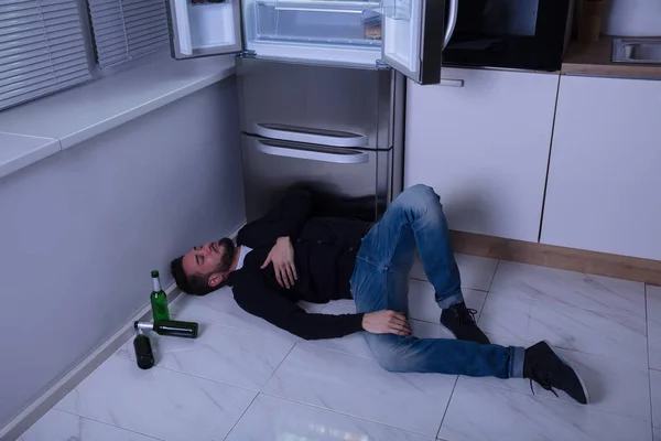 Мужчина лежит на полу на кухне — стоковое фото