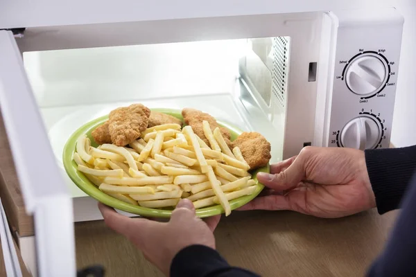 Pessoa que coloca alimentos fritos — Fotografia de Stock