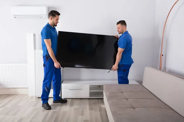 Two Movers Placing Television — Stok Foto