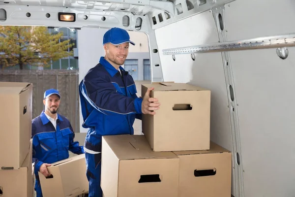 Movers transportando caixas de papelão — Fotografia de Stock