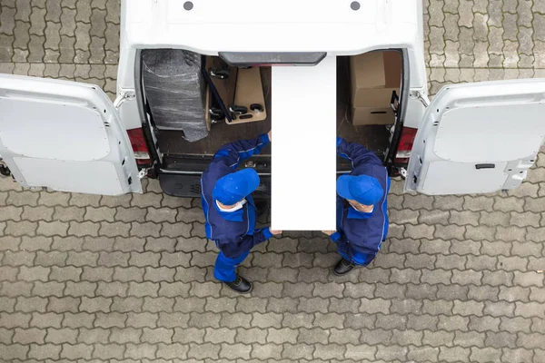 Trabalhadores descarregando móveis de caminhão — Fotografia de Stock