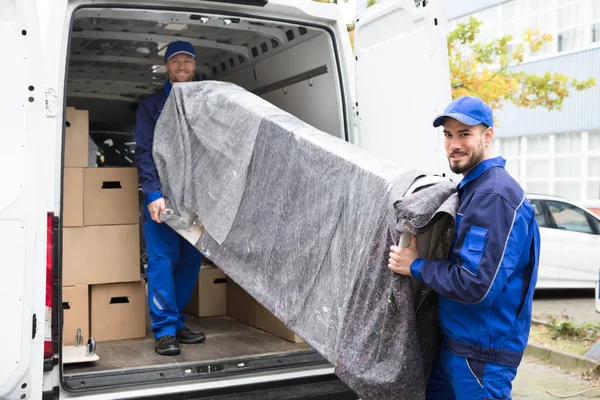 Рабочие разгружают мебель из грузовика — стоковое фото