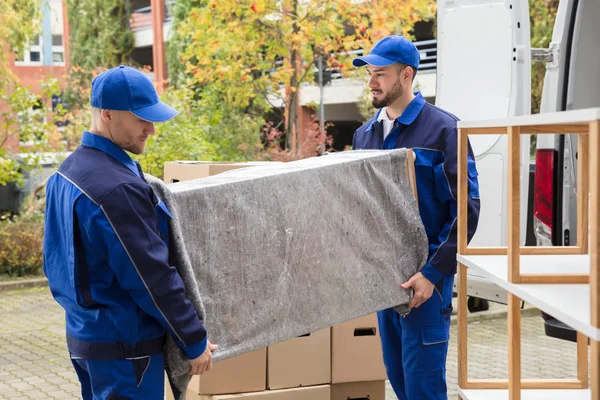 Werknemers meubelen uit vrachtwagen lossen — Stockfoto