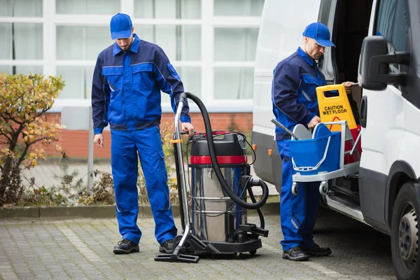 Conciërges lossen reinigingsapparatuur — Stockfoto