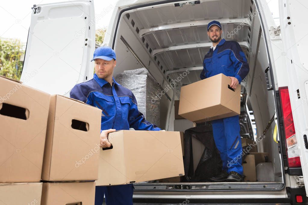 Movers Carrying Cardboard Boxes