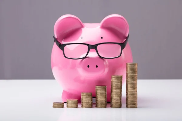 Piggybank och staplade mynt — Stockfoto