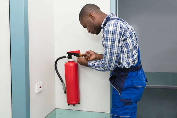 Mannelijke Professional controleren van een brandblusser — Stockfoto