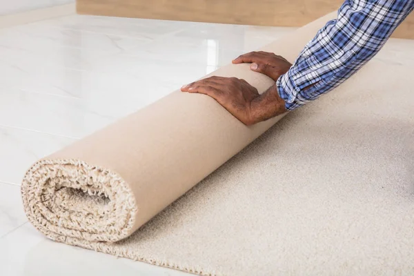 Worker's Hands Rolling Carpet — Stock Photo, Image