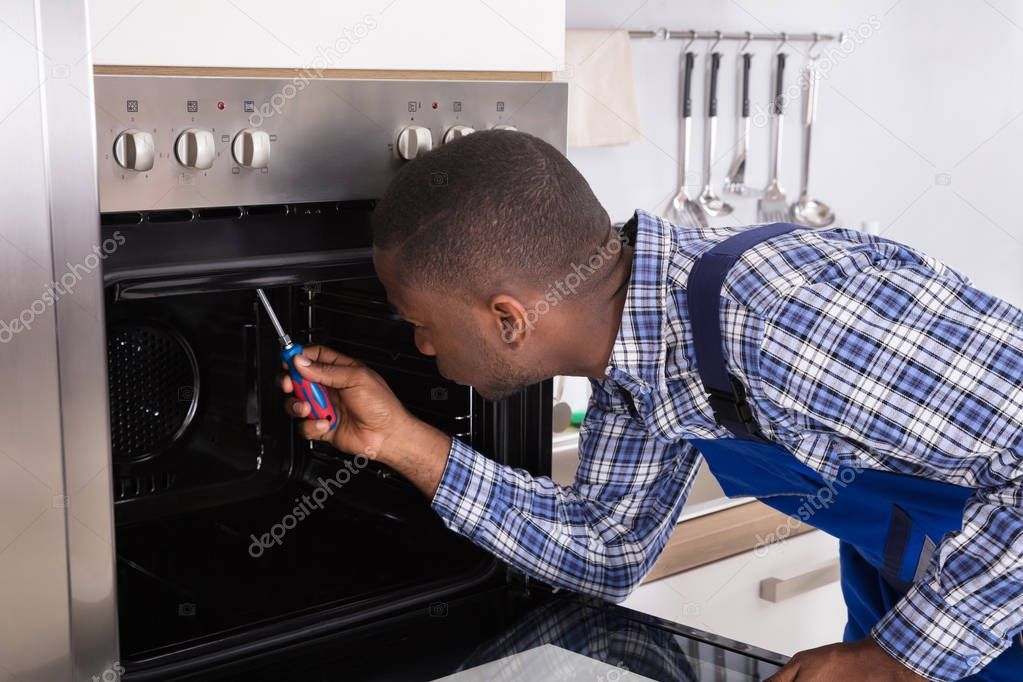 Repairman Fixing Kitchen Oven