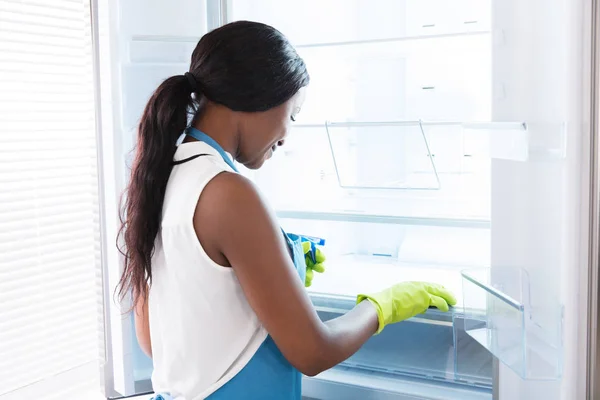 Africano donna pulizia frigorifero — Foto Stock