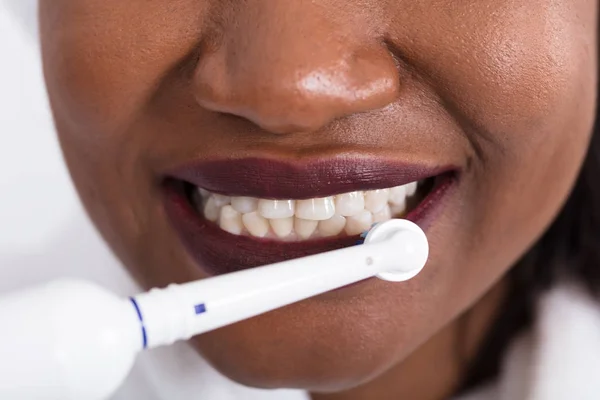 Женские зубы с электрической зубной щеткой — стоковое фото