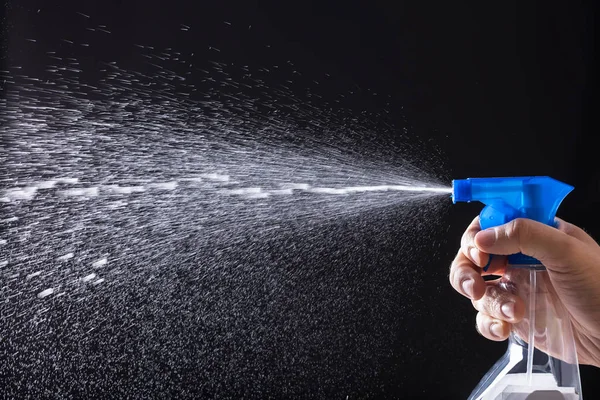 Agua de pulverización de mano humana con botella de pulverización — Foto de Stock