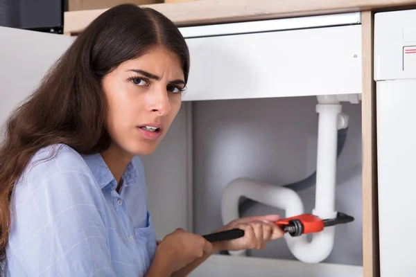 Young Woman Tightening Sink Pipe — Stock Photo, Image