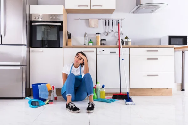 Vrouw zittend op de keukenvloer — Stockfoto