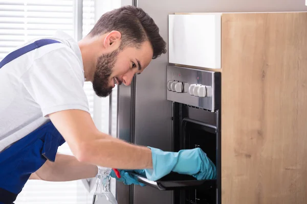 Janitor Cleaning Oven In Kitchen — Stock Photo, Image