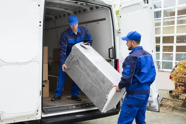 Männer laden Möbel aus Fahrzeug — Stockfoto