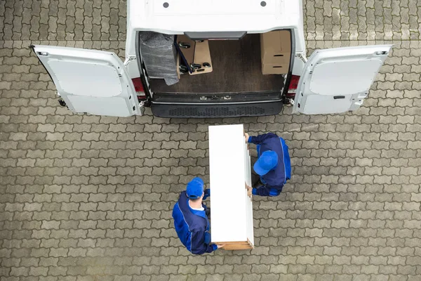 Homens de entrega descarregando móveis — Fotografia de Stock