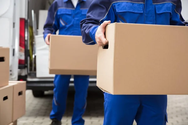Movers transportando caixas de papelão — Fotografia de Stock