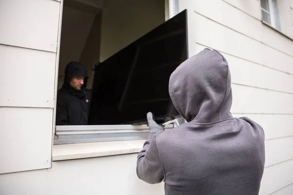 Overvallers stelen van televisie — Stockfoto