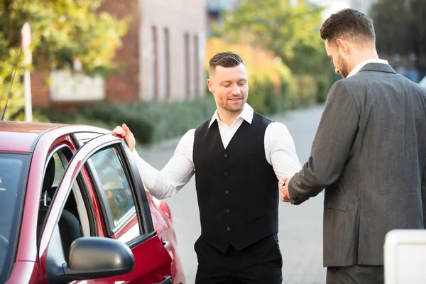 Parcheggiatore e uomo d'affari vicino auto — Foto Stock