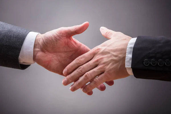 Бізнес-партнери тремтять руками — стокове фото