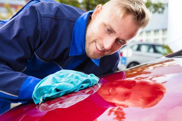 Arbetstagare rengöring röd bil — Stockfoto