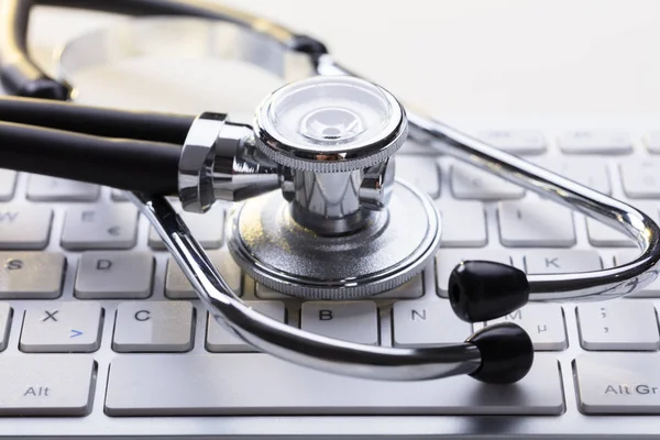 Estetoscópio médico no teclado do computador — Fotografia de Stock