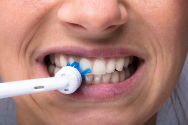 Elektrikli diş fırçası ile kadının diş