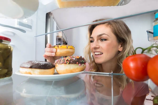 Kvinnan tar Donut — Stockfoto